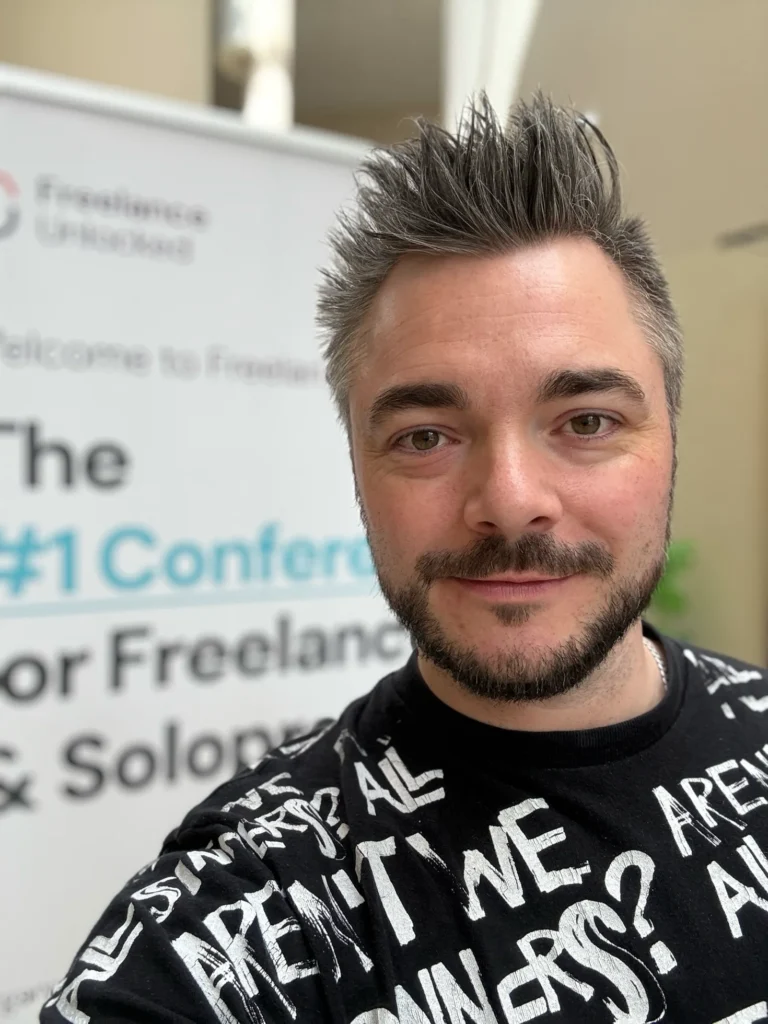 Oli vor einem Banner der Konferenz Freelance Unlocked