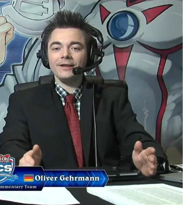 Oli im Anzug mit Headset als Kommentator der Yu-Gi-Oh! Championship Series London