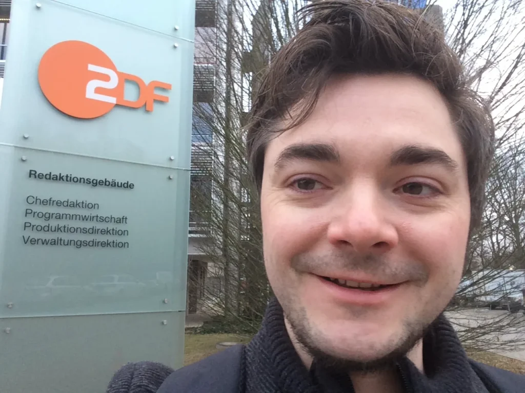 Oli vor dem Schild des ZDF-Redaktionsgebäudes